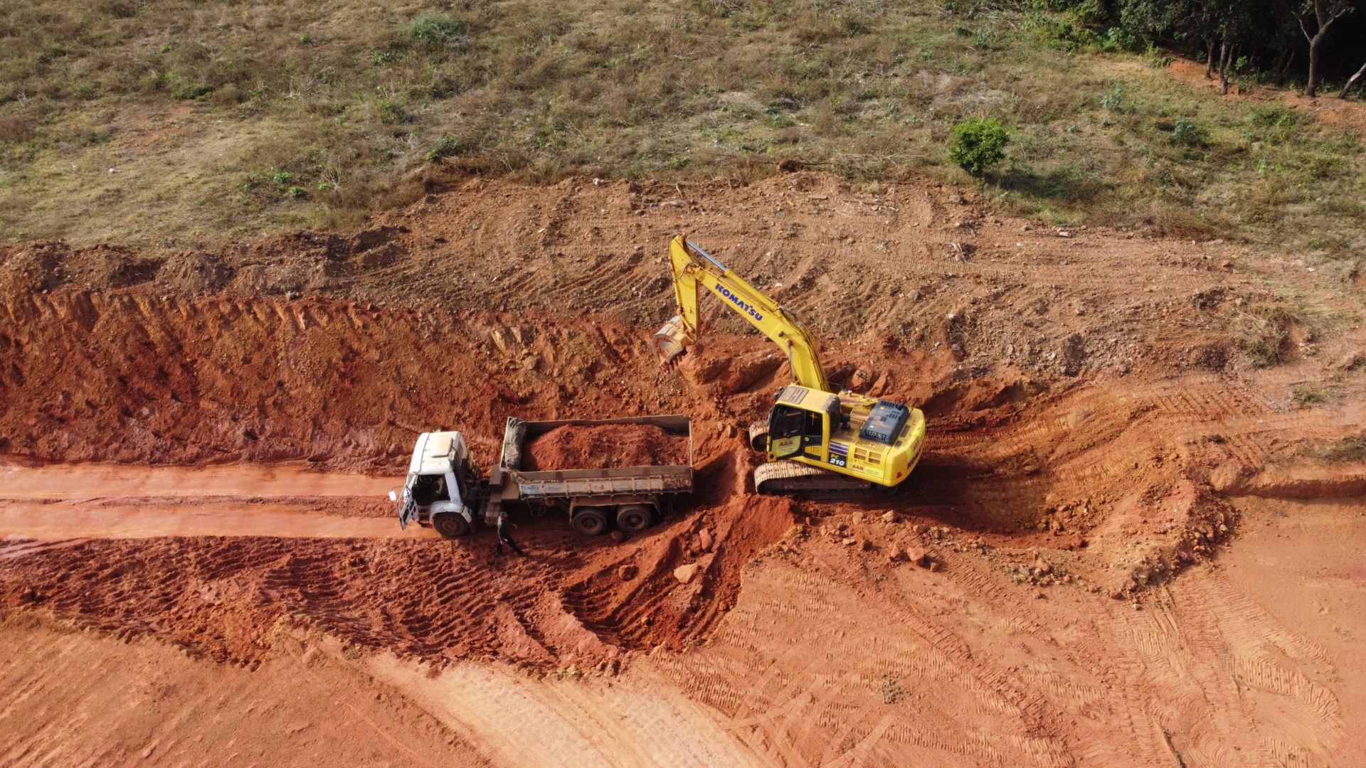 Vista aérea de escavadeira e caminhão caçamba da A&B em obra de terraplanagem em Araguari